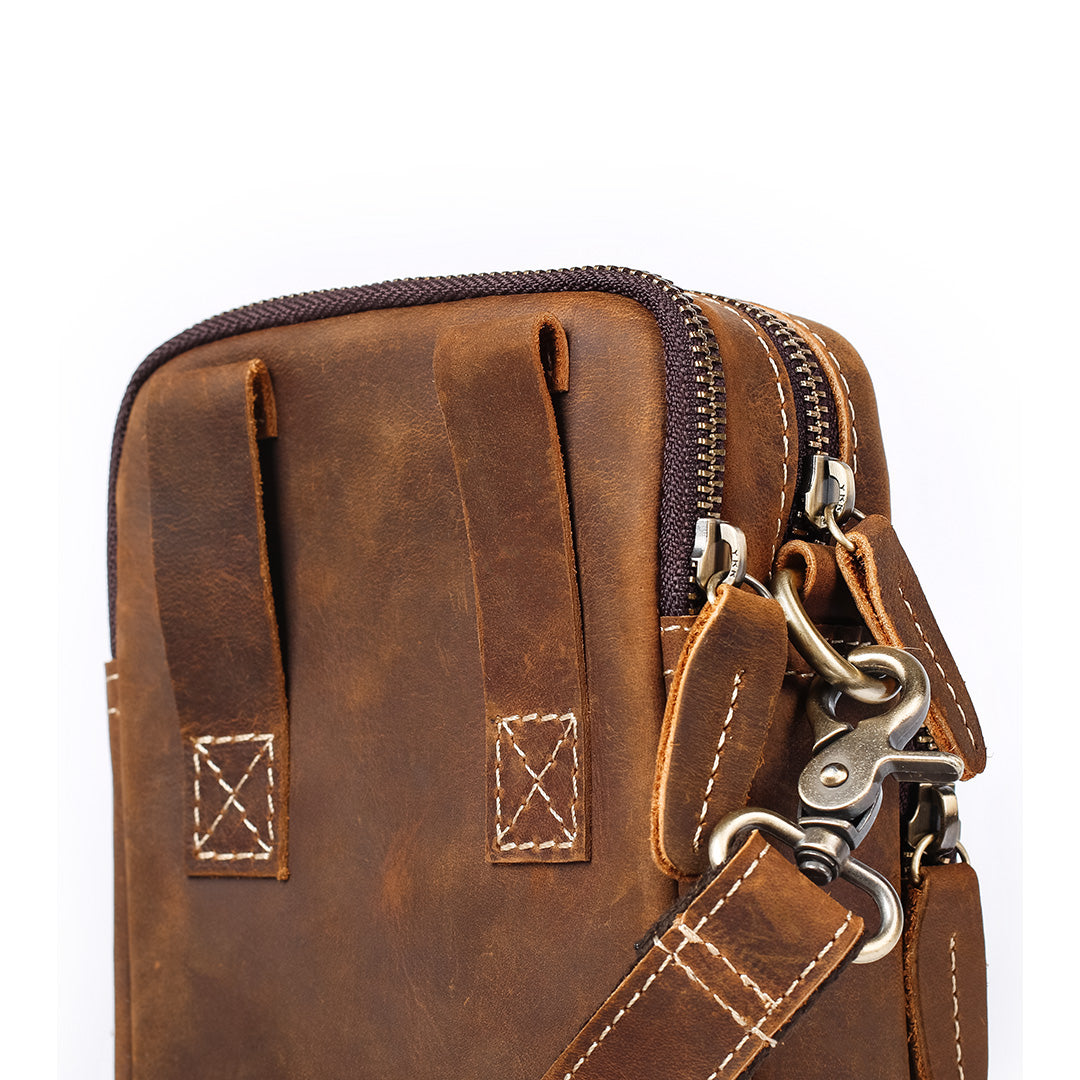 Brown leather pouch with zippers and keychain on a white background