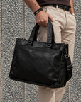 Executive black leather laptop briefcase for men with dual carry handles, detachable shoulder strap and structured rectangular design