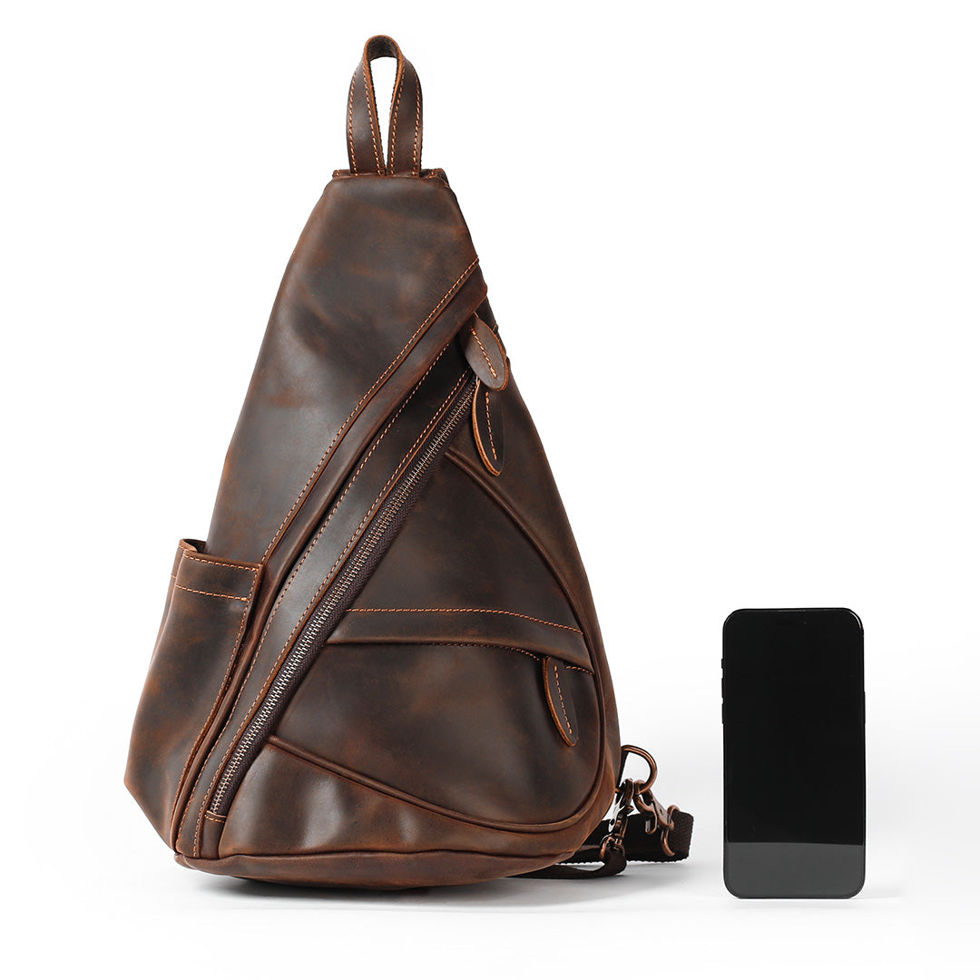 Brown leather sling bag with a smartphone on a white background