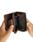 Hands holding a premium leather wallet, showcasing spacious compartments for organized storage.