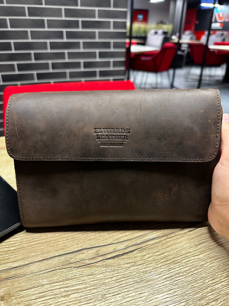 High-quality leather wrist bag for men with secure closure and practical strap.