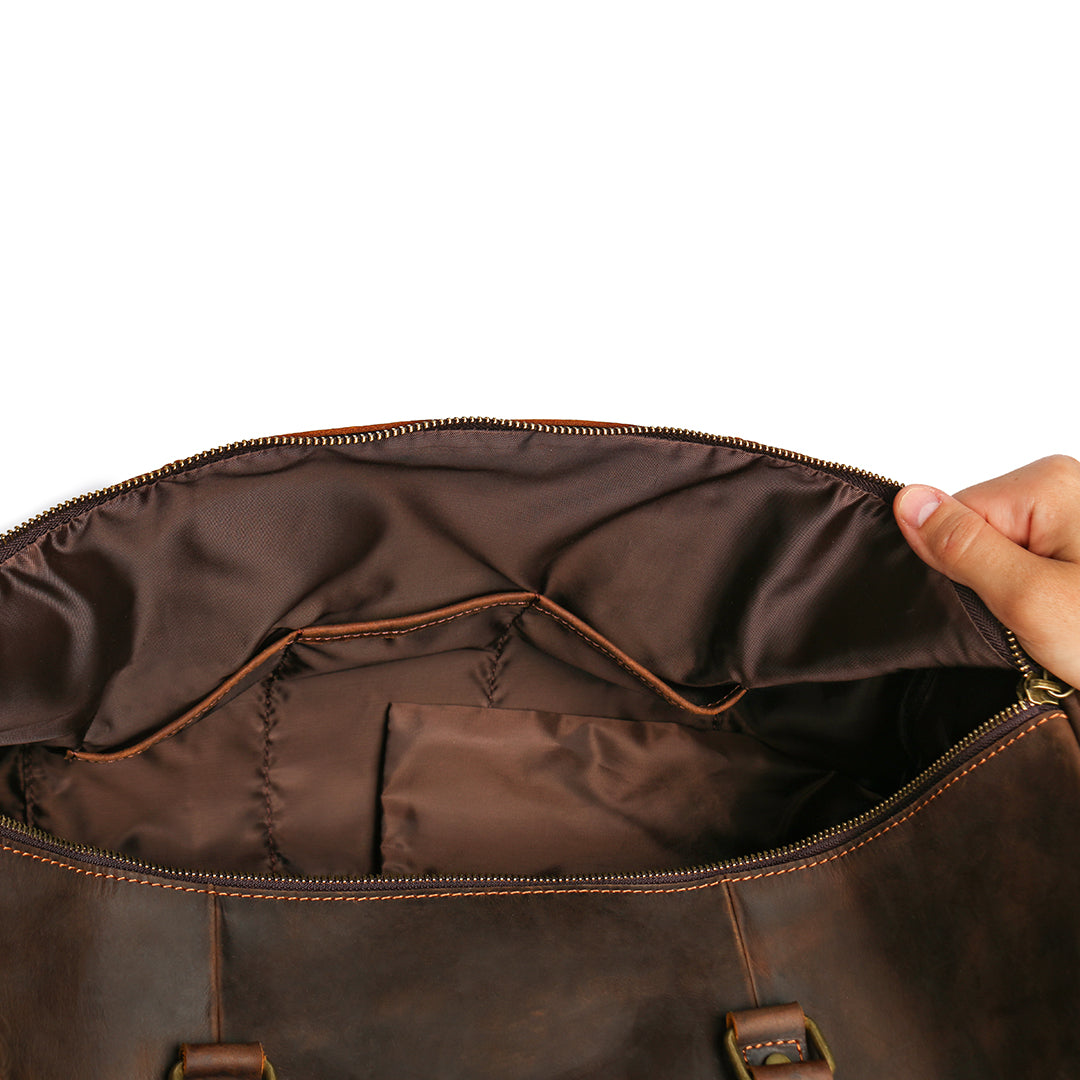 Interior view of a brown Crazy Horse leather duffle bag with reinforced lining and multiple compartments.