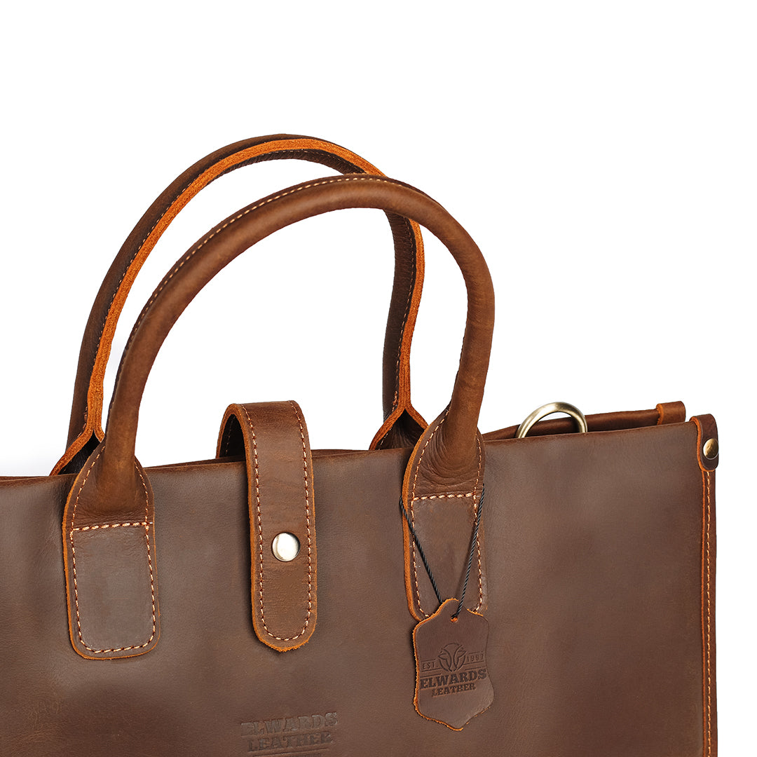 Interior of a men&#39;s brown leather tote bag showing organizational pockets and durable lining.