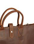 Interior of a men's brown leather tote bag showing organizational pockets and durable lining.