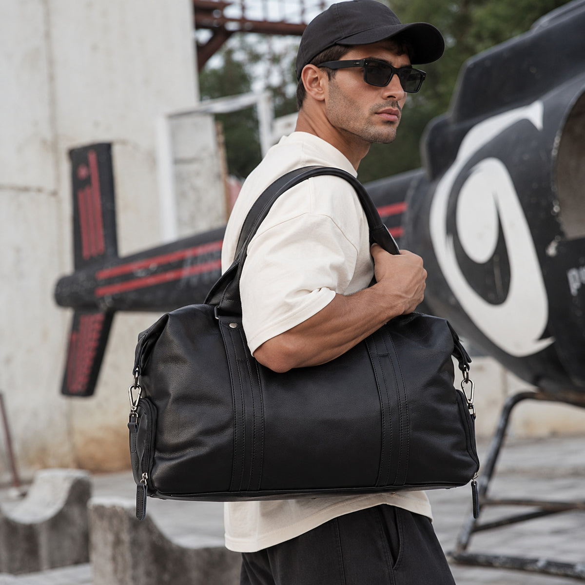 Large black leather overnight bag for men with dual handles, detachable shoulder strap and spacious weekender shape