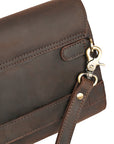 Close-up of a brass hook and leather strap on the back of a dark brown clutch, showcasing durability and premium hardware.