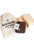 Brown leather wallet with branded packaging, displayed with a soft pouch and gift box, perfect for gifting.