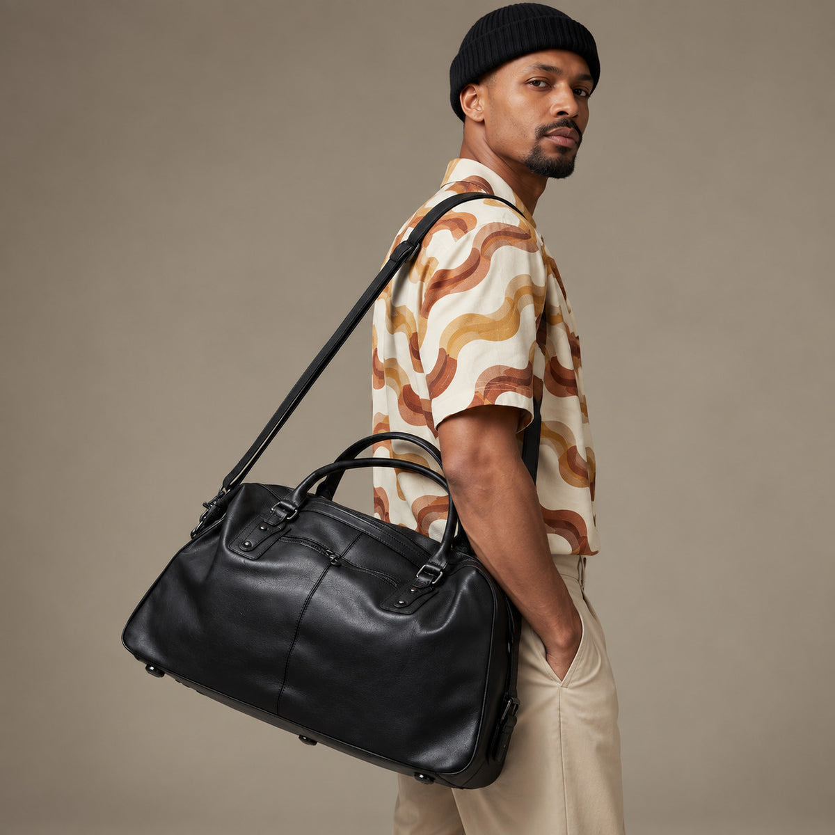 Luxury black leather travel duffle bag for men with top handles, detachable shoulder strap and roomy overnight design