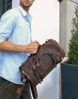Male model holding a vintage Crazy Horse leather backpack in urban style, perfect for modern travel and casual outings.