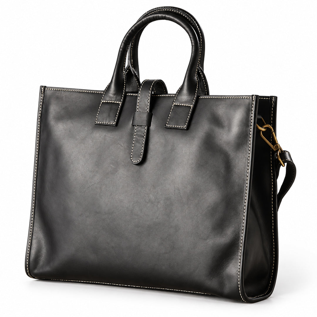 Men's black full-grain leather tote bag at an angle showing the stitched front and narrow side gusset