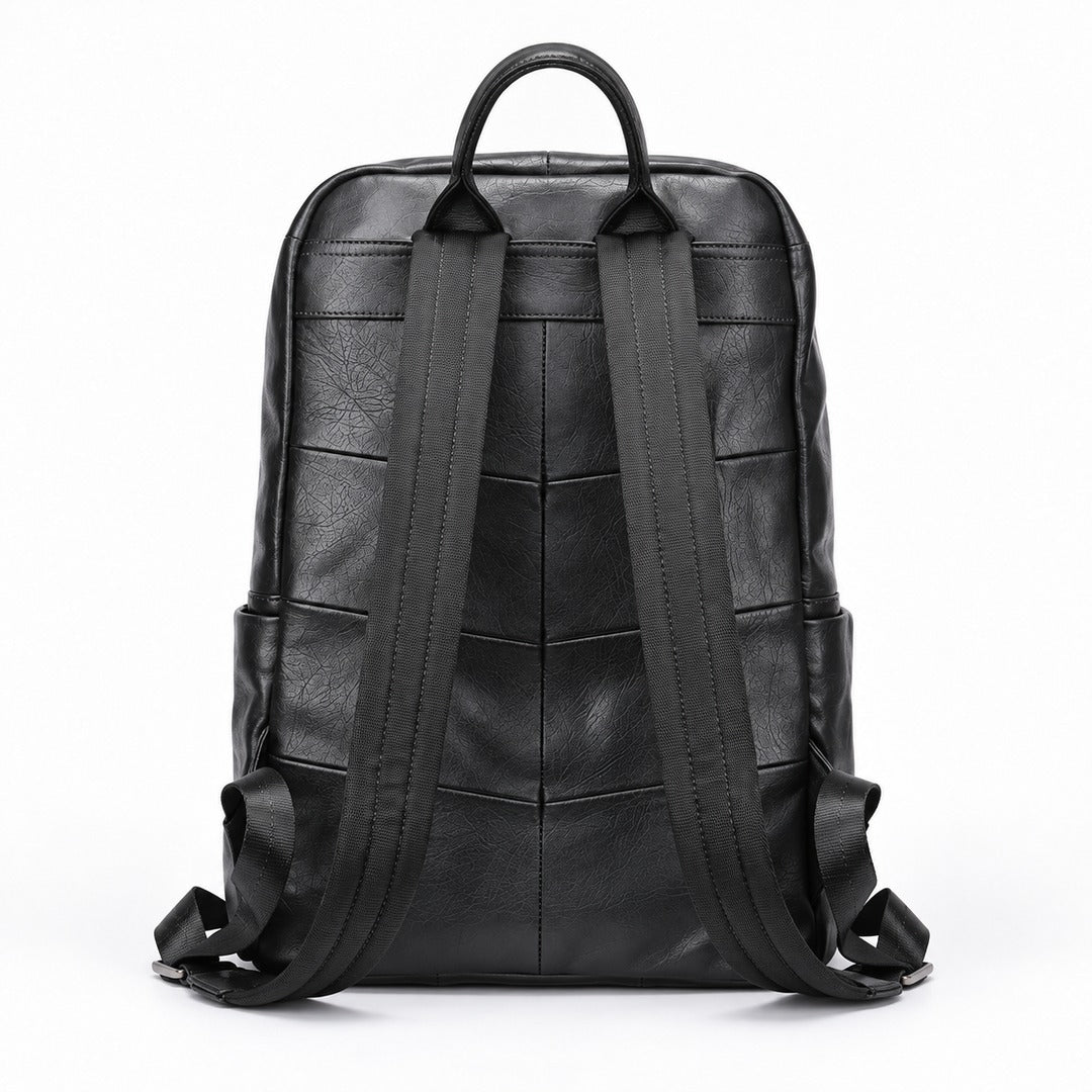 Black leather backpack shown from the back, featuring a quilted chevron pattern on the back panel, a top handle, and wide padded shoulder straps, photographed on a white background.