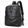 Black leather backpack with multiple zippered compartments and padded shoulder straps, shown on a plain white background.