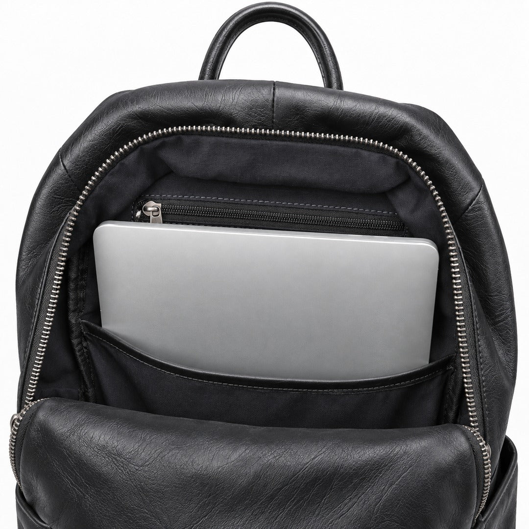Black leather backpack shown open, displaying a silver laptop in the front pocket and a black zippered interior compartment, on a white background.