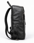A black leather backpack shown from a side profile view, featuring a front zippered pocket and a padded shoulder strap, set against a plain white background.