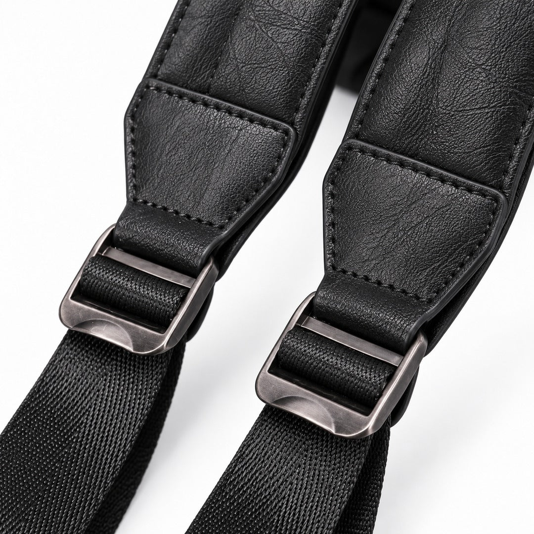 Close-up of a black camera strap with textured faux leather webbing and silver metal quick-release buckles on a white background.