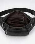 Black leather waist bag with an open front zipper, multiple interior zip pockets, and a black adjustable webbing strap with a plastic buckle, shown on a white background.