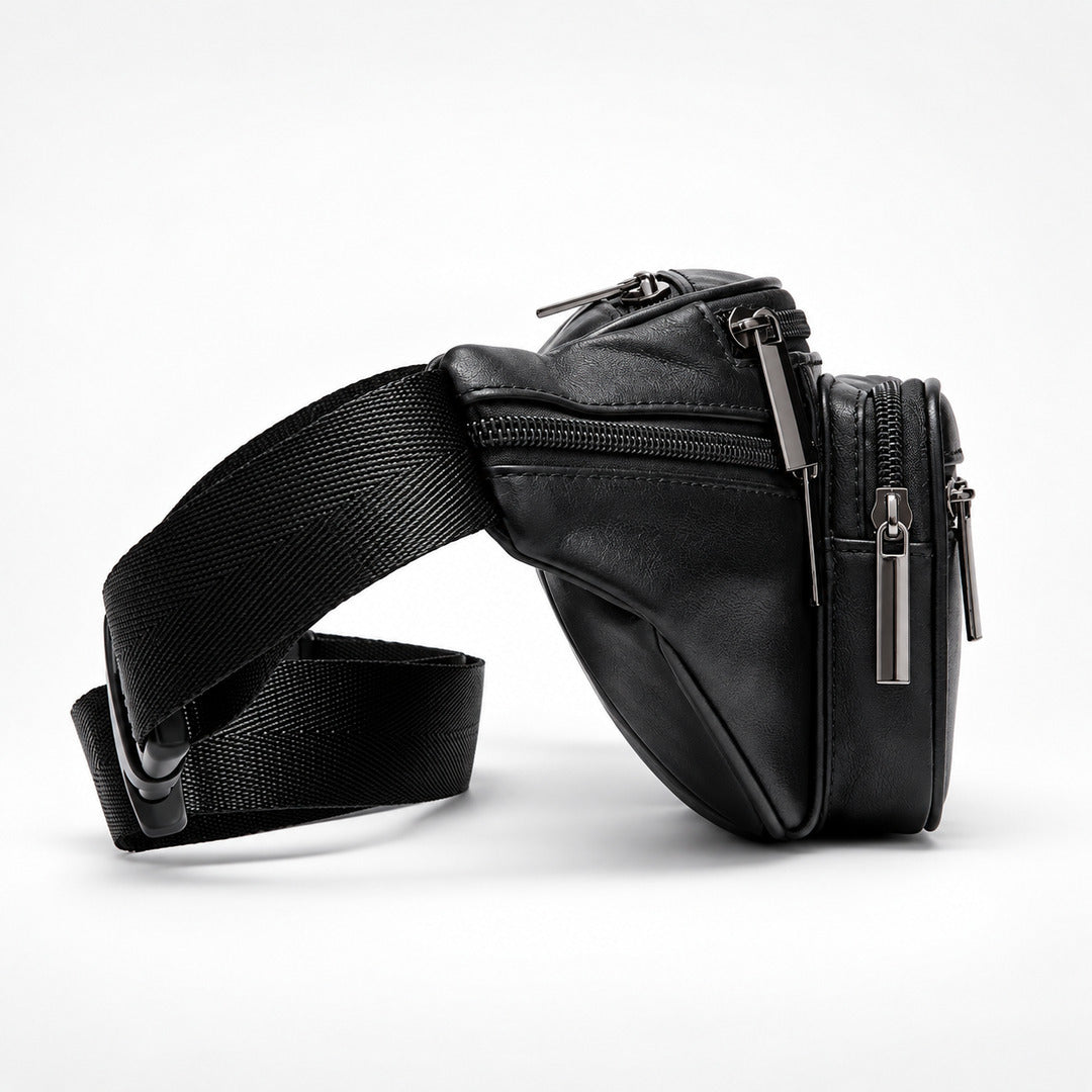 A black leather fanny pack with an adjustable black webbing strap, featuring multiple zippered compartments and silver-tone hardware, photographed on a clean white studio background.