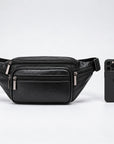 A black genuine leather fanny pack with multiple zippered compartments and silver-tone hardware, shown next to a black smartphone for scale on a light gray background.