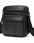 Black pebbled leather crossbody bag with multiple zippered compartments and a wide adjustable shoulder strap, shown on a clean white background.