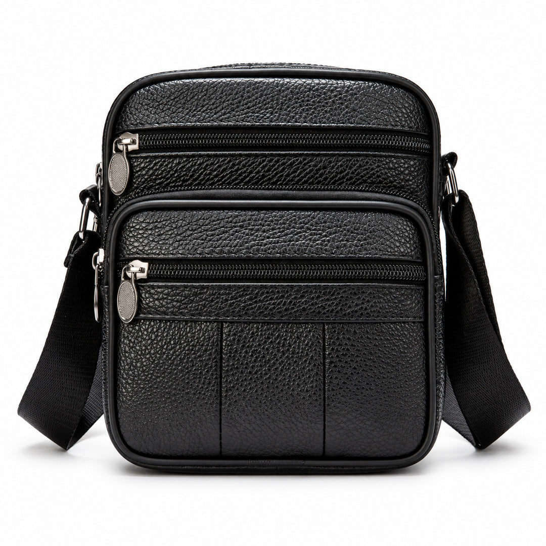 Black pebbled leather crossbody bag with multiple zippered compartments and a wide adjustable shoulder strap, shown on a clean white background.