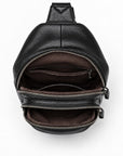 Black pebbled leather crossbody bag shown open from a top-down view, revealing a dark brown interior with multiple zippered compartments and a silver zipper.