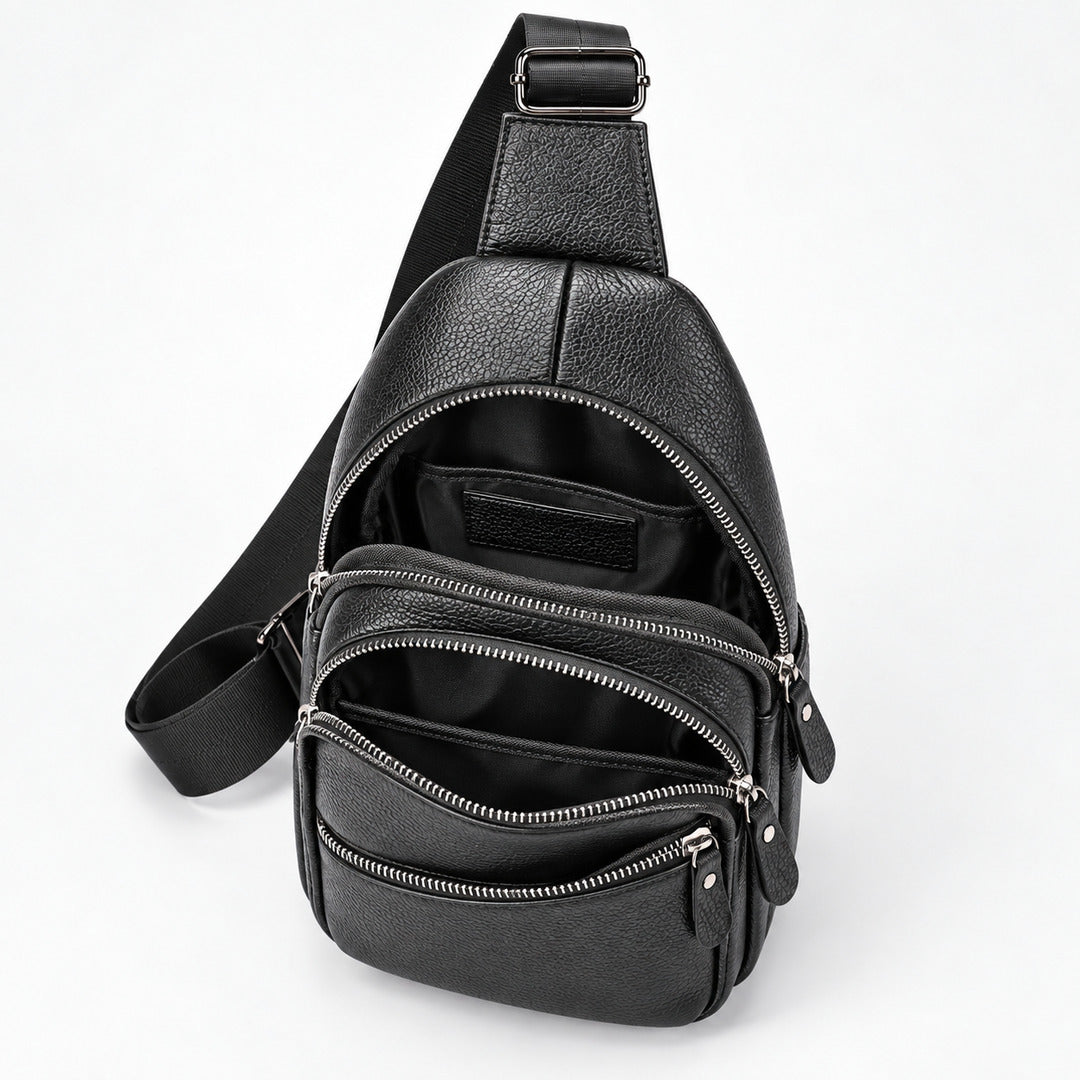 Black pebbled leather crossbody bag with multiple zippered compartments and an adjustable shoulder strap, shown open on a white background.