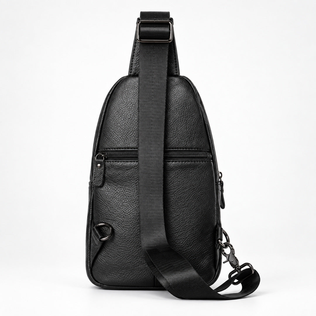 Black textured leather sling bag with a wide adjustable shoulder strap, shown from the back on a white studio background.