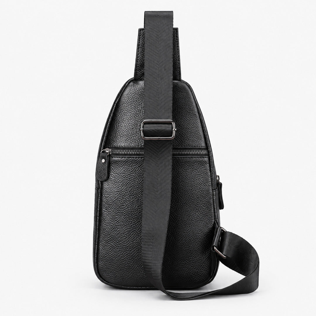 Black pebbled leather crossbody bag with a front zippered pocket and adjustable shoulder strap, shown on a light gray background.