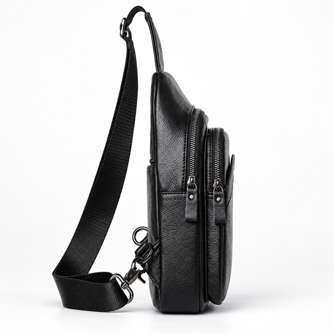 Black pebbled leather crossbody bag with a wide adjustable shoulder strap, shown from a side profile view against a white background.