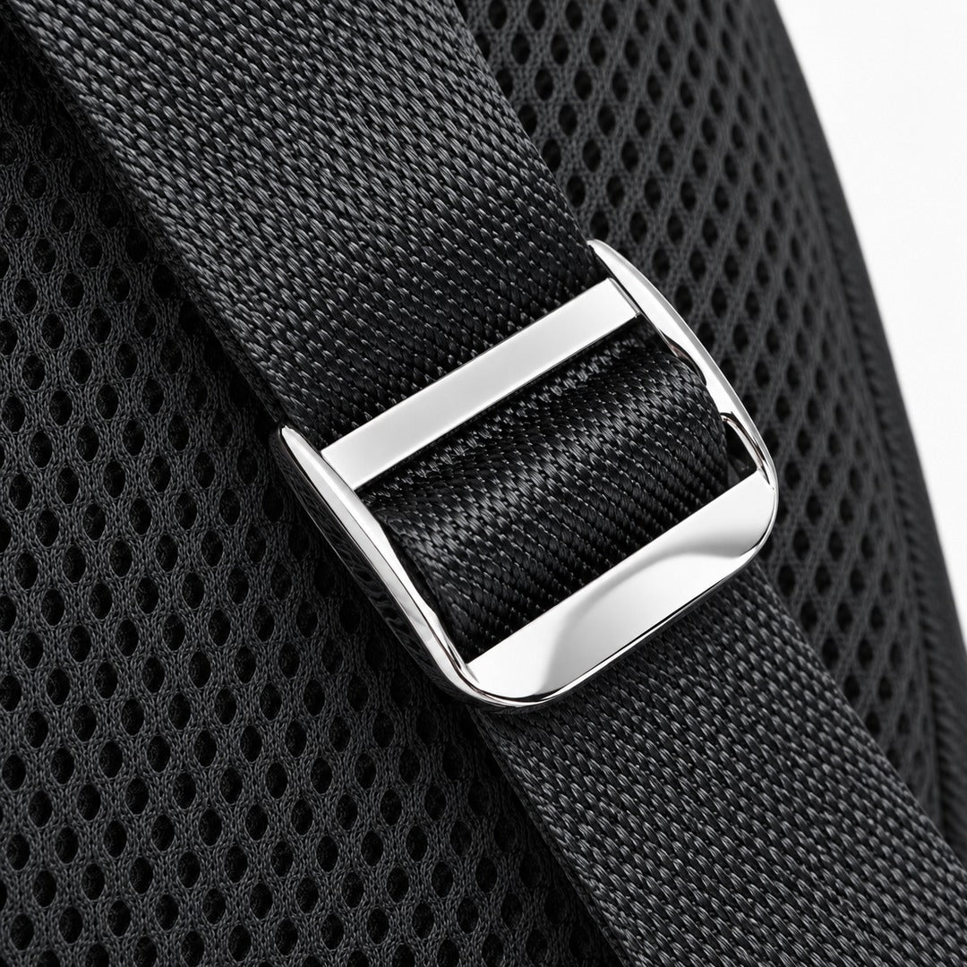Close-up of a black woven strap with a polished silver metal buckle over a black mesh fabric background.