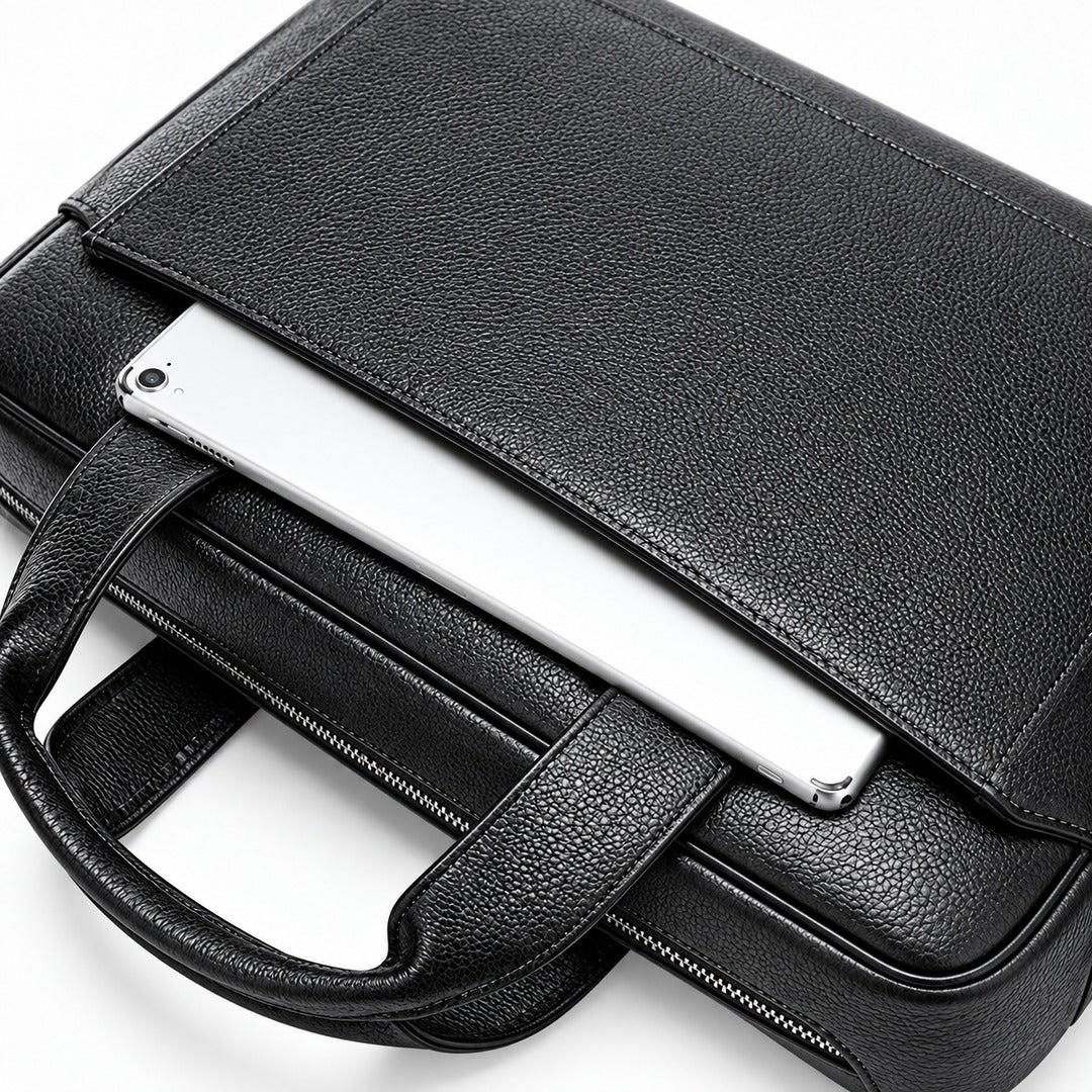 Black pebbled leather laptop briefcase with a top flap pocket holding a silver tablet, shown on a white background.