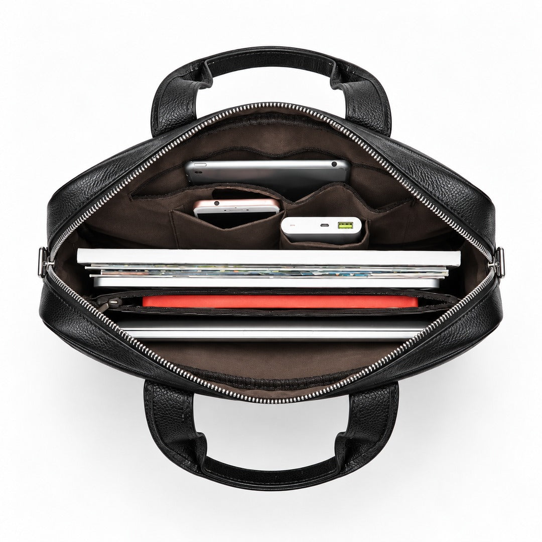 Top-down view of an open black leather laptop bag showing its interior organization with compartments holding a tablet, phone, power bank, and accessories, on a white background.