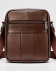 A brown textured leather crossbody bag with a matching adjustable shoulder strap, shown against a plain light gray background.