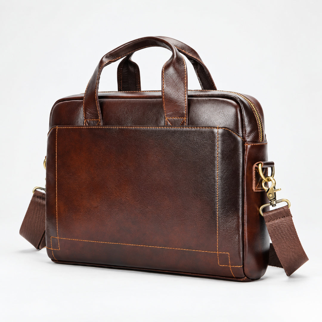 A dark brown leather briefcase with dual top handles, a detachable shoulder strap, and gold-tone hardware, photographed on a clean white studio background.