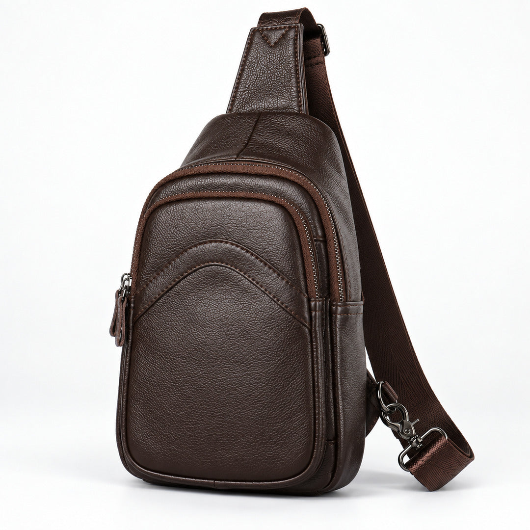 A dark brown textured leather sling bag with an adjustable shoulder strap, shown from a three-quarter angle on a white background.