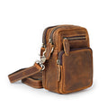 Brown leather crossbody bag with multiple zippers on a white background