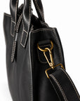Men's black full-grain leather tote bag strap attachment with a gold-tone clasp and stitched leather tab