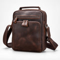 A dark brown distressed leather crossbody bag with multiple zippered compartments, a top handle, and an adjustable shoulder strap, shown on a light gray background.