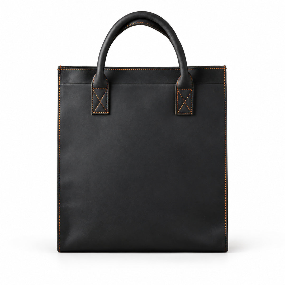 Minimalist black full-grain leather tote with rounded handles and brown contrast stitching