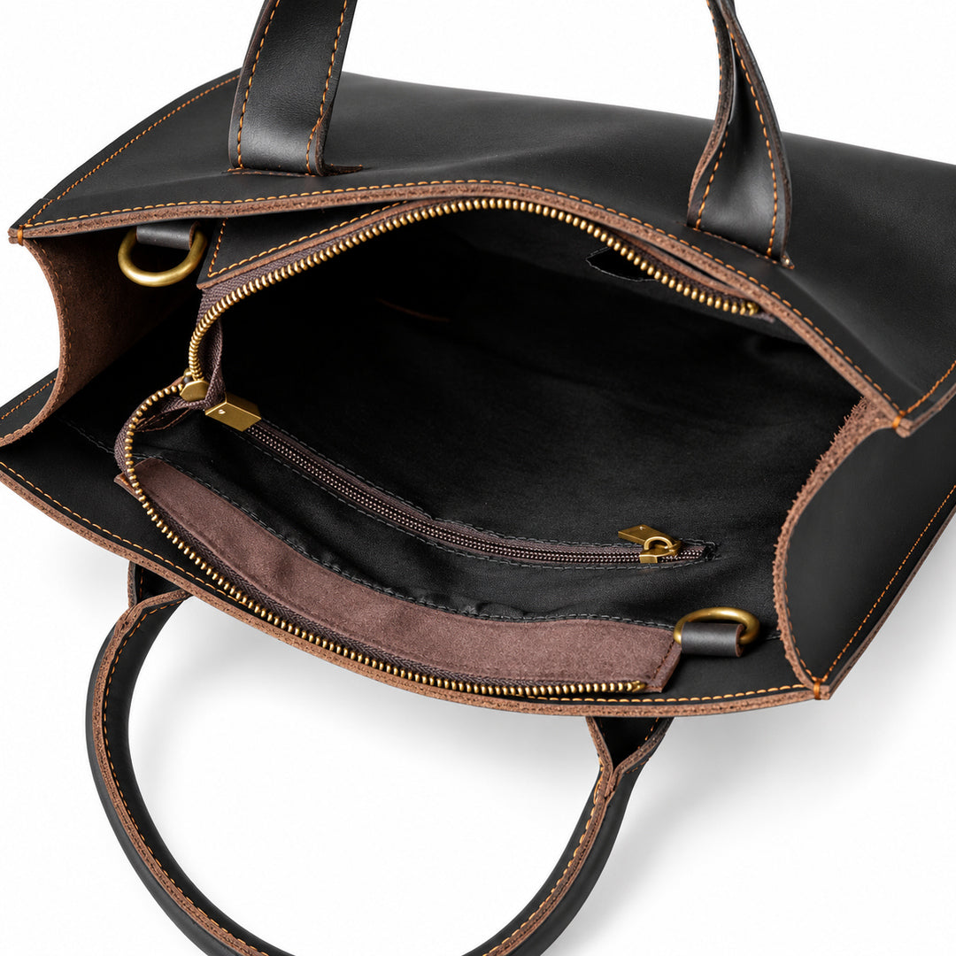 Minimalist black full-grain leather tote interior with a zip pocket and black fabric lining