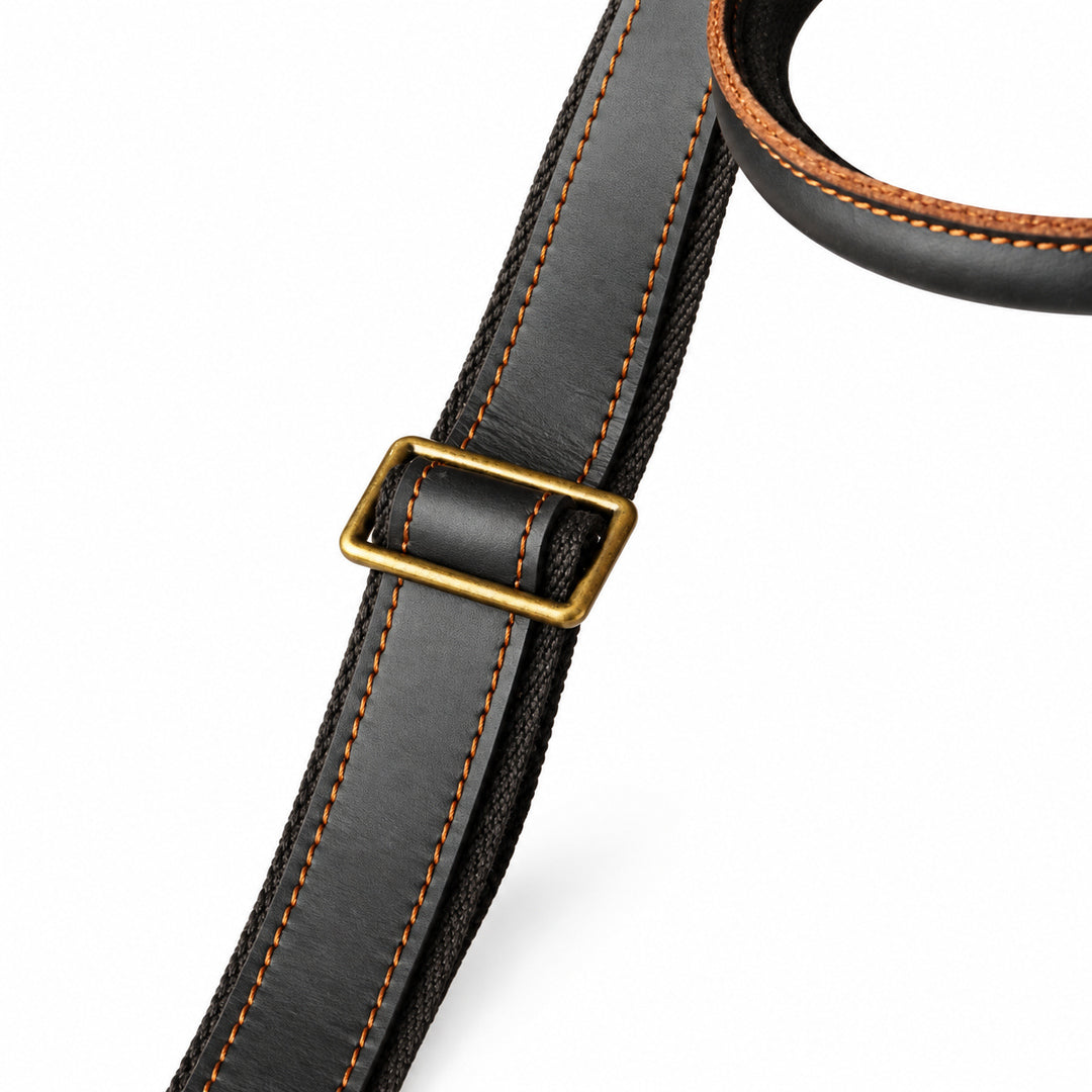 Minimalist black full-grain leather tote shoulder strap with brown stitching and a metal adjuster