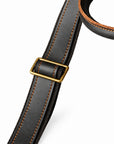 Minimalist black full-grain leather tote shoulder strap with brown stitching and a metal adjuster