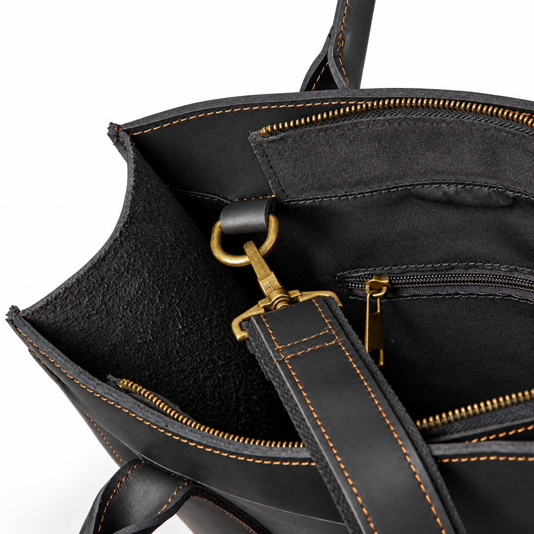 Minimalist black full-grain leather tote strap clip attached to an interior metal ring