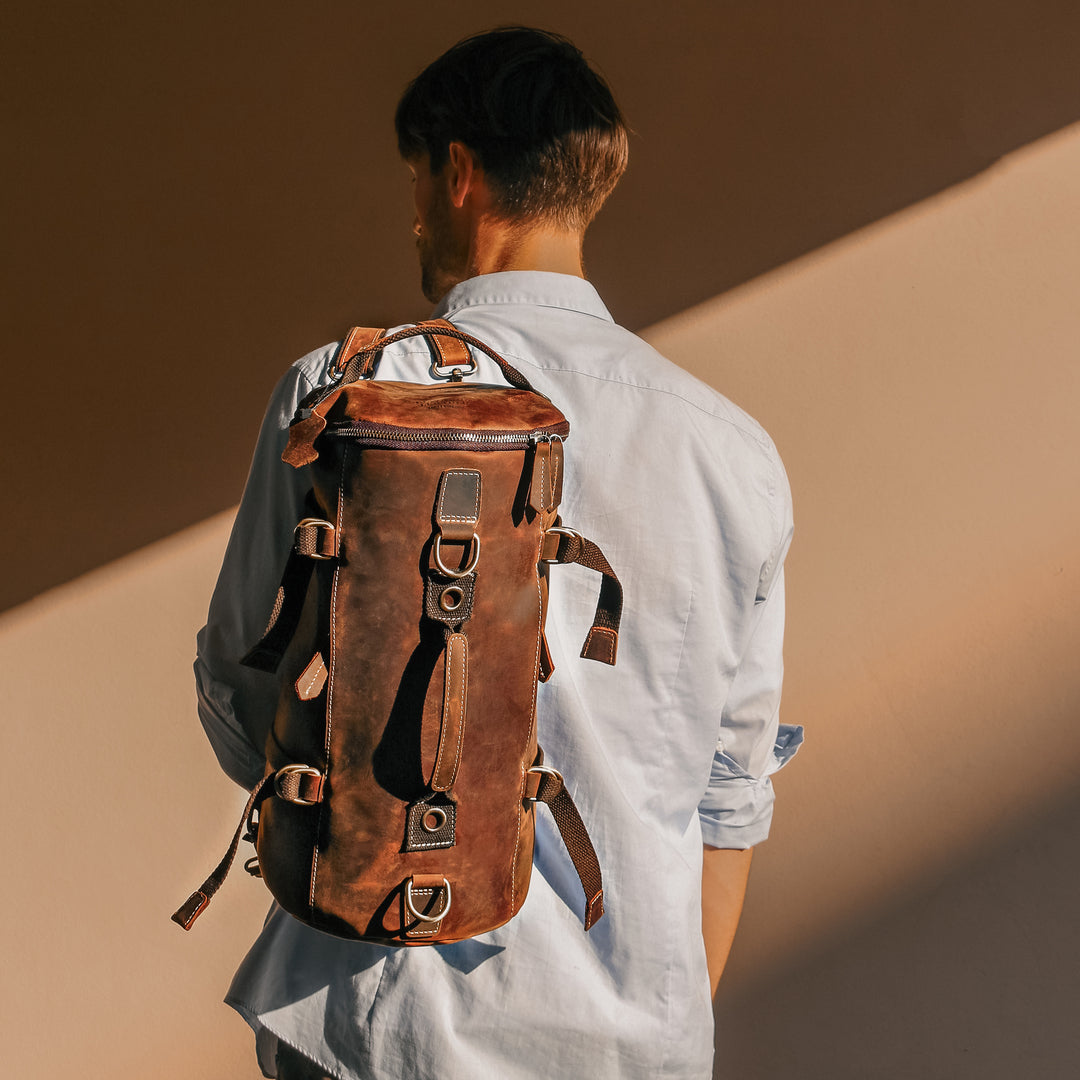 Model carrying a vintage leather backpack, handcrafted from durable Crazy Horse leather for style and practicality