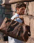 Model carrying a vintage Crazy Horse leather duffle bag, perfect for travel or carry-on, blending style and function.