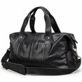 Modern black full-grain leather duffel bag at an angle showing the zippered side pocket.