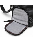 Modern black full-grain leather duffel bag with an open side pocket and gray fabric lining.
