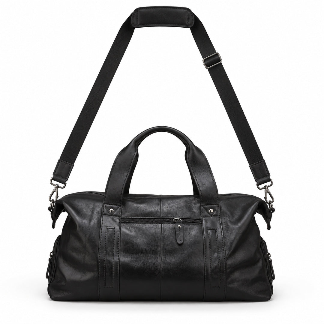 Modern black full-grain leather duffel bag with its adjustable shoulder strap raised above.