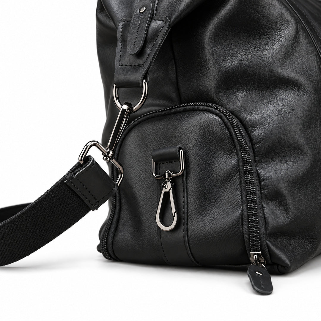 Modern black full-grain leather duffel bag side pocket detail with silver-tone clips.