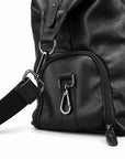 Modern black full-grain leather duffel bag side pocket detail with silver-tone clips.
